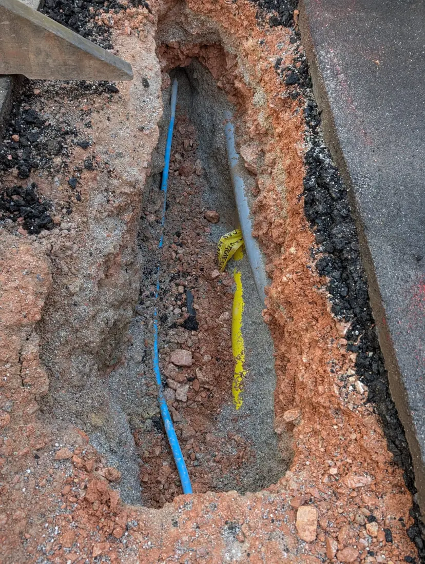 Exposed services in a vacuum-excavated trench