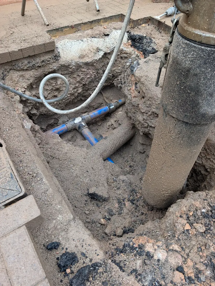 Vacuum excavation hose exposing a blue water pipe